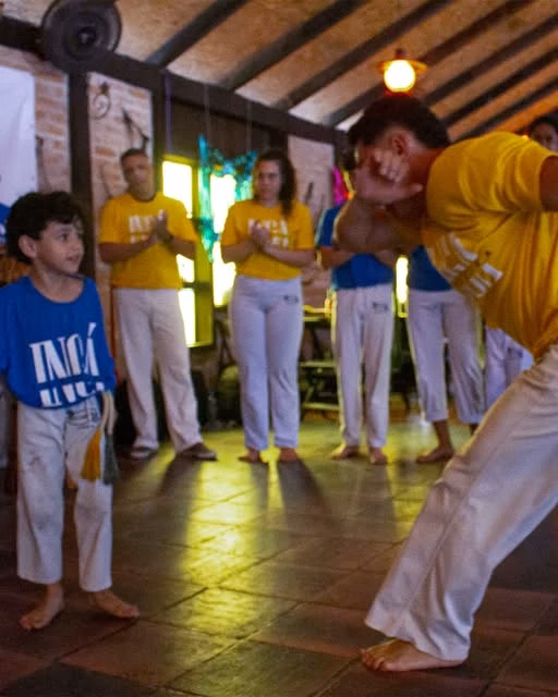 Criança e adulto participando da roda do Ingá Capoeira